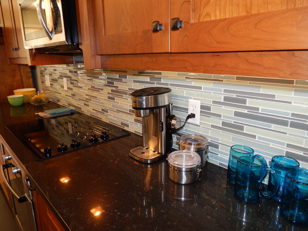 Example of a mid-sized transitional l-shaped cork floor eat-in kitchen design with an undermount sink, shaker cabinets, medium tone wood cabinets, quartz countertops, blue backsplash, glass tile backsplash, stainless steel appliances, blue walls and an island