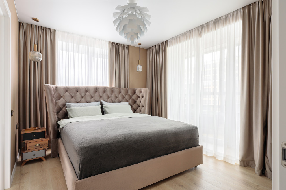 Mittelgroßes Skandinavisches Schlafzimmer mit beiger Wandfarbe, braunem Holzboden und braunem Boden in Sankt Petersburg