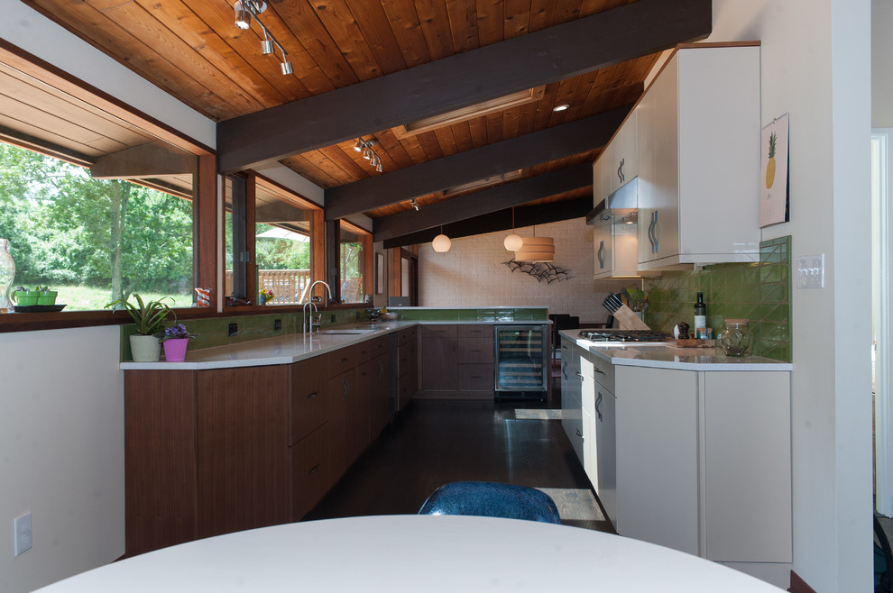 Inspiration for a 1960s dark wood floor and brown floor kitchen remodel in Wilmington with an undermount sink, flat-panel cabinets, quartz countertops, green backsplash, stainless steel appliances, a peninsula and white countertops