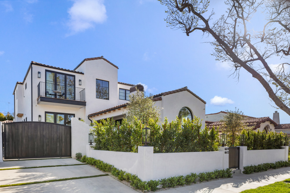 Großes, Zweistöckiges Mediterranes Einfamilienhaus mit weißer Fassadenfarbe, Satteldach, Ziegeldach und braunem Dach in Los Angeles