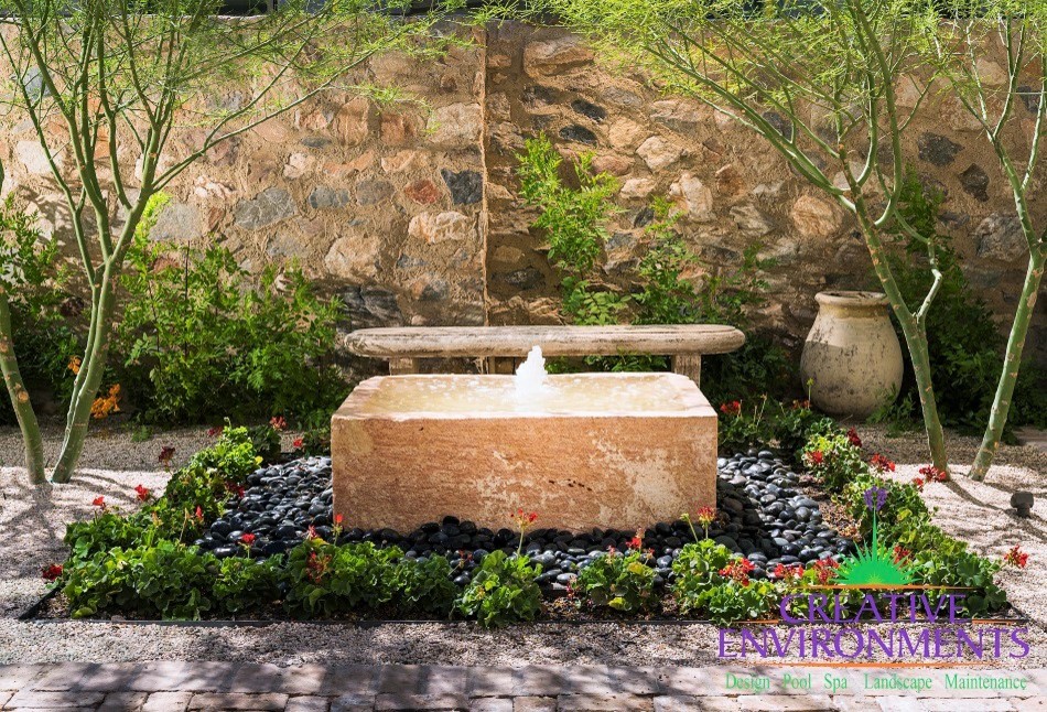 Pool fountain - mid-sized rustic backyard decomposed granite and rectangular pool fountain idea in Phoenix