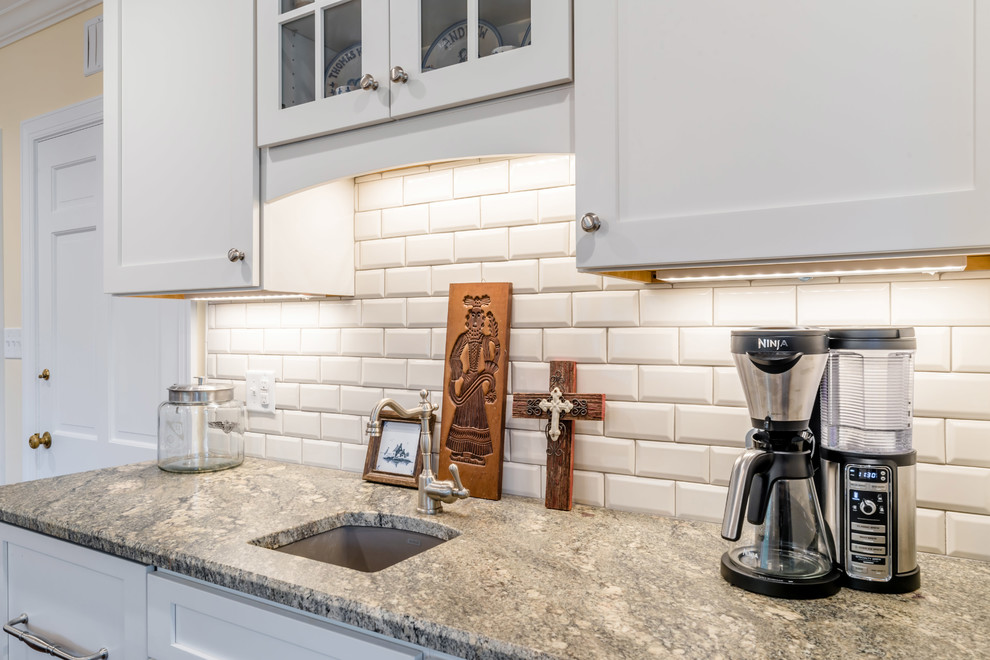 Inspiration for an expansive traditional galley eat-in kitchen in Miami with an undermount sink, shaker cabinets, white cabinets, granite benchtops, white splashback, subway tile splashback, stainless steel appliances, medium hardwood floors and with island.
