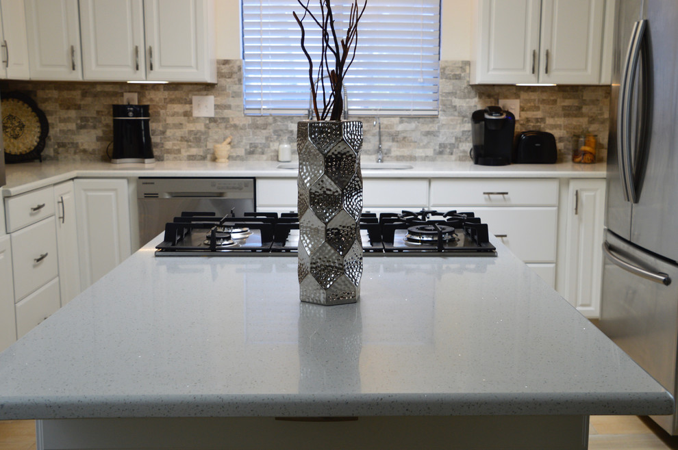 Mid-sized transitional l-shaped porcelain tile enclosed kitchen photo in Albuquerque with an undermount sink, raised-panel cabinets, white cabinets, quartz countertops, beige backsplash, porcelain backsplash, stainless steel appliances and no island