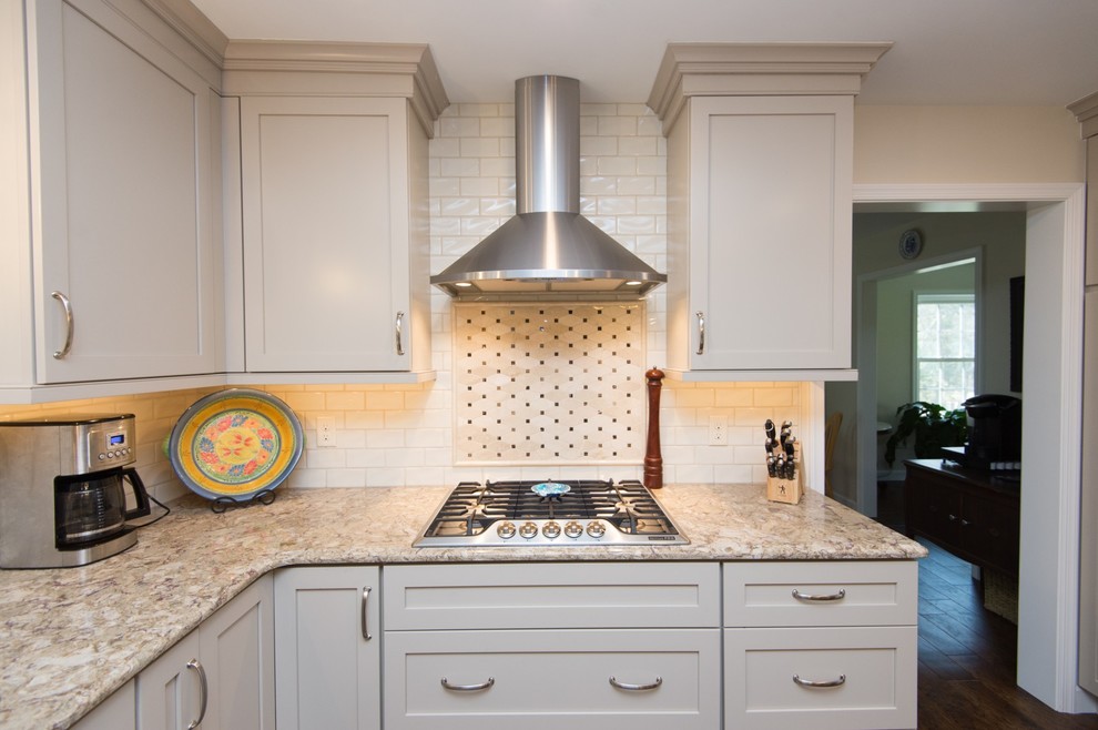Eat-in kitchen - transitional u-shaped vinyl floor and brown floor eat-in kitchen idea with an undermount sink, shaker cabinets, quartz countertops, subway tile backsplash, stainless steel appliances and an island