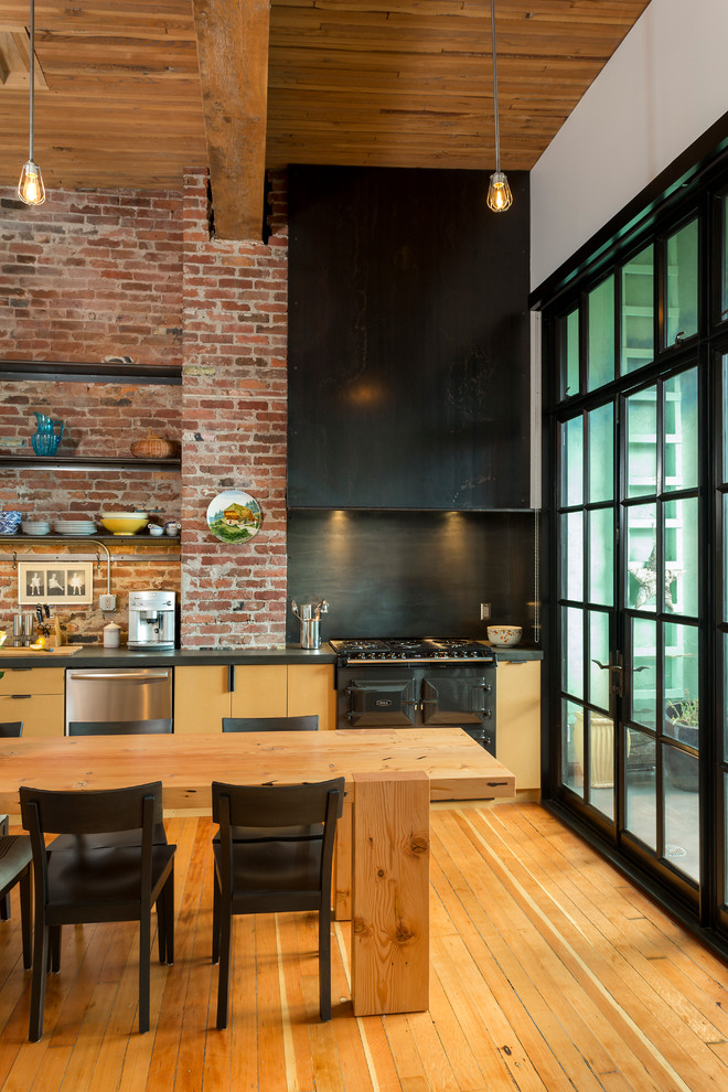 Photo of an industrial single-wall eat-in kitchen in Seattle with an undermount sink, flat-panel cabinets, medium wood cabinets, stainless steel appliances and medium hardwood floors.