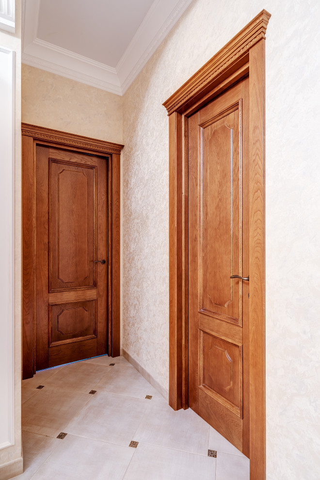 На фото: коридор среднего размера в классическом стиле с белым полом и обоями на стенах с