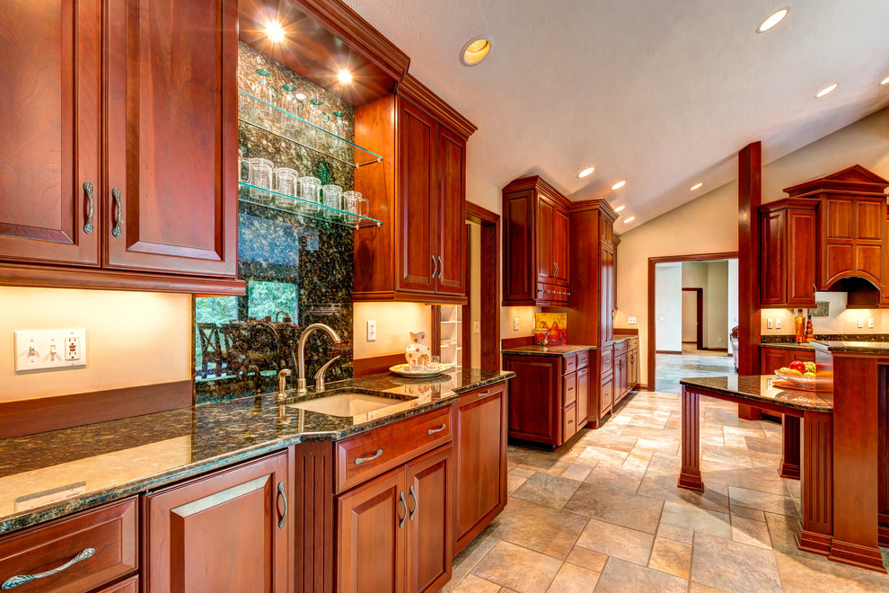 This is an example of an expansive traditional kitchen in Cleveland with a submerged sink, raised-panel cabinets, dark wood cabinets, granite worktops, integrated appliances, ceramic flooring and an island.
