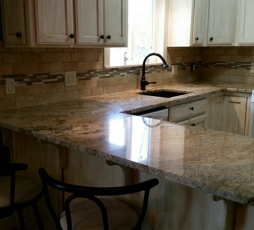Inspiration for a mid-sized transitional u-shaped eat-in kitchen remodel in Seattle with an undermount sink, recessed-panel cabinets, distressed cabinets, granite countertops, beige backsplash, stone tile backsplash, white appliances and a peninsula