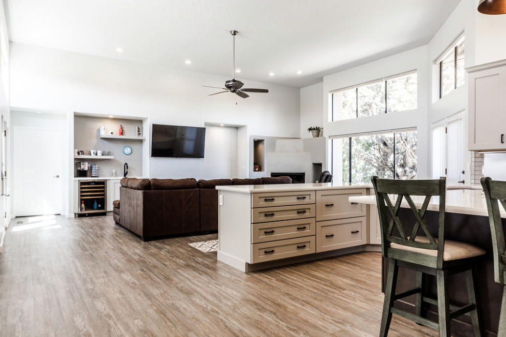 Example of a large transitional u-shaped vinyl floor and gray floor eat-in kitchen design with an undermount sink, shaker cabinets, gray cabinets, quartzite countertops, green backsplash, subway tile backsplash, stainless steel appliances, an island and white countertops