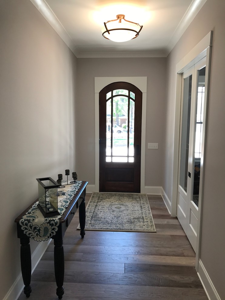 This is an example of a mid-sized arts and crafts foyer in Raleigh with beige walls, dark hardwood floors, a single front door, a dark wood front door and brown floor.