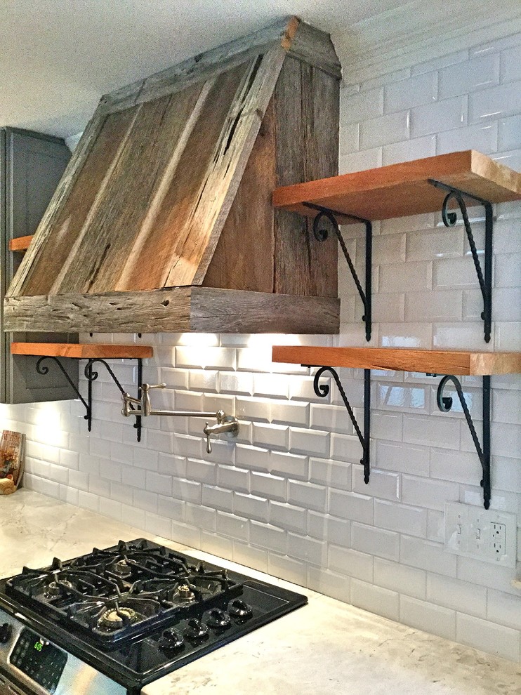 Inspiration for a mid-sized rustic u-shaped light wood floor open concept kitchen remodel in Atlanta with a farmhouse sink, shaker cabinets, gray cabinets, quartzite countertops, white backsplash, subway tile backsplash, stainless steel appliances and a peninsula