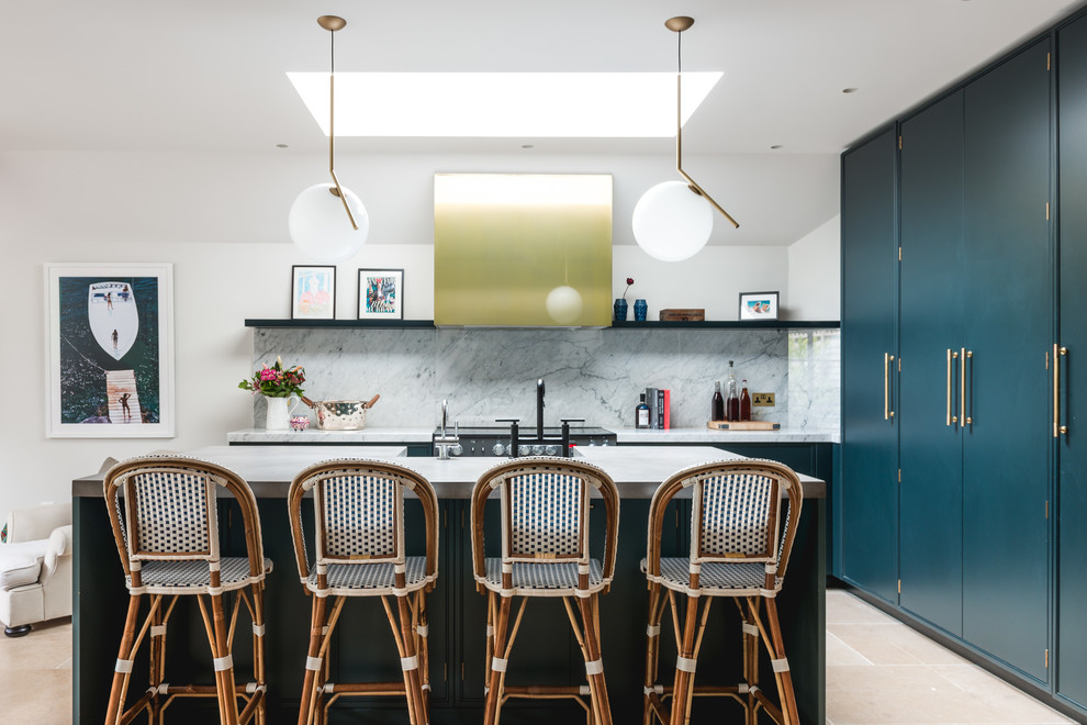 This is an example of a large transitional l-shaped kitchen in London with an integrated sink, flat-panel cabinets, blue cabinets, concrete benchtops, grey splashback, marble splashback, stainless steel appliances, cement tiles, with island and beige floor.
