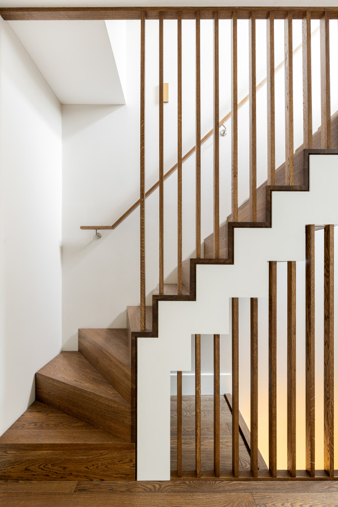 Mid-sized contemporary wood staircase in London with wood risers and wood railing.
