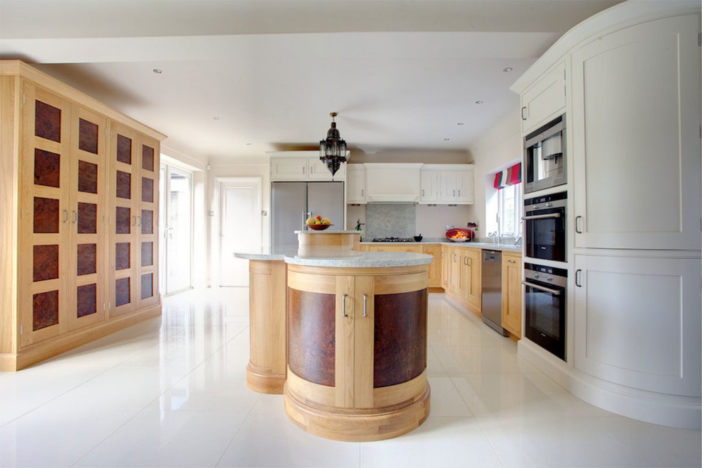 This is an example of a contemporary kitchen/diner in Cheshire with a built-in sink, shaker cabinets, white cabinets, granite worktops, grey splashback, stainless steel appliances, a breakfast bar and grey worktops.