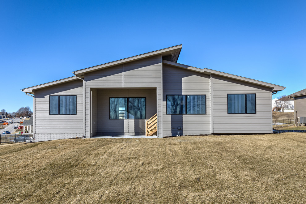 Modern one-story mixed siding flat roof idea in Omaha with a shingle roof