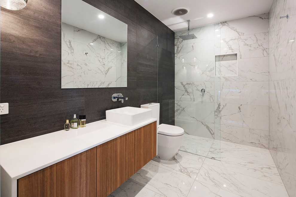 Mid-sized contemporary master bathroom in Brisbane with medium wood cabinets, black tile, marble floors, a vessel sink, engineered quartz benchtops, an open shower, flat-panel cabinets, a curbless shower and white floor.