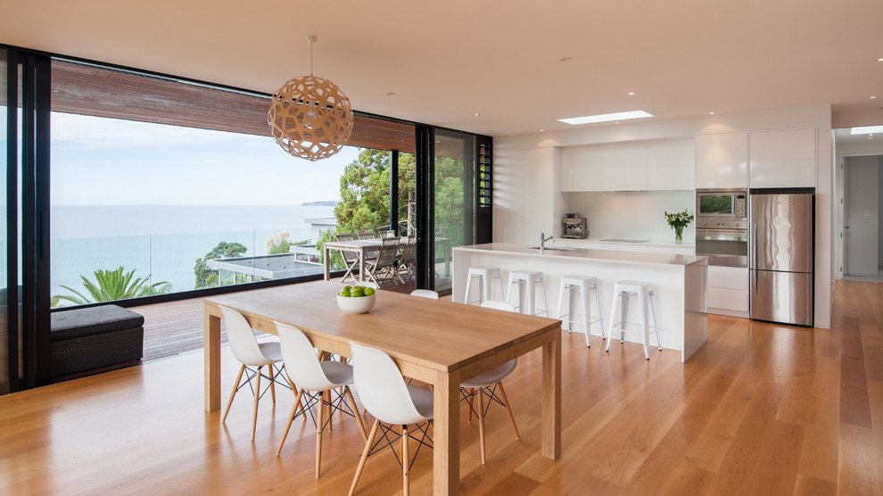 Design ideas for a contemporary open plan dining in Auckland with medium hardwood floors.