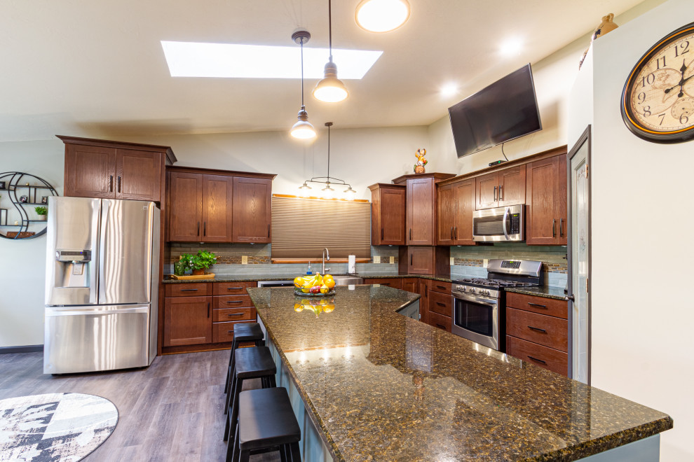 Foto på ett stort lantligt flerfärgad kök, med en rustik diskho, skåp i shakerstil, skåp i mellenmörkt trä, granitbänkskiva, grönt stänkskydd, stänkskydd i keramik, rostfria vitvaror, vinylgolv, en köksö och brunt golv