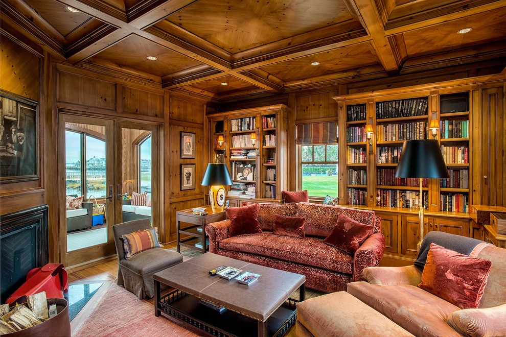 This is an example of a mid-sized traditional home office in New York with a library, medium hardwood floors, a corner fireplace, a wood fireplace surround, brown walls and brown floor.