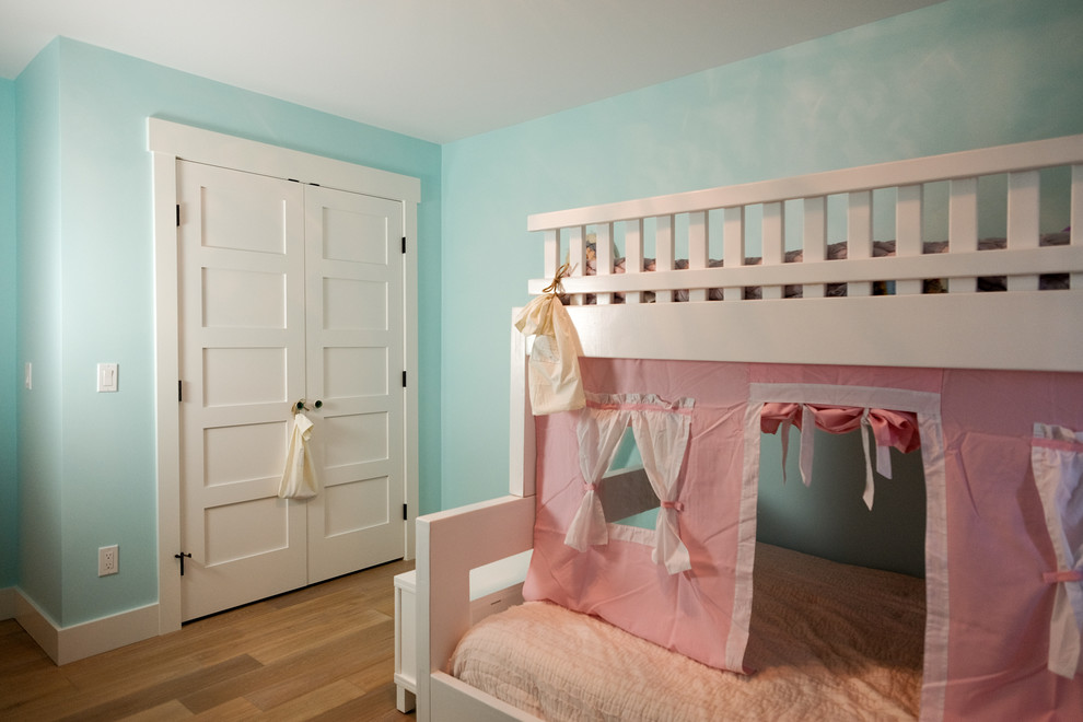 Photo of a mid-sized beach style kids' bedroom for kids 4-10 years old and girls in Grand Rapids with blue walls and medium hardwood floors.