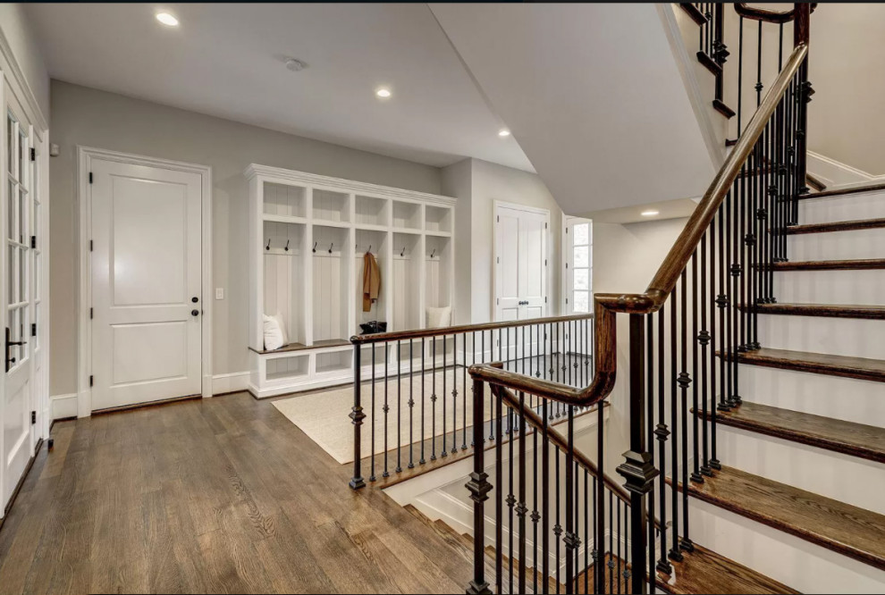 This is an example of a large classic wood floating metal railing staircase in DC Metro with painted wood risers.