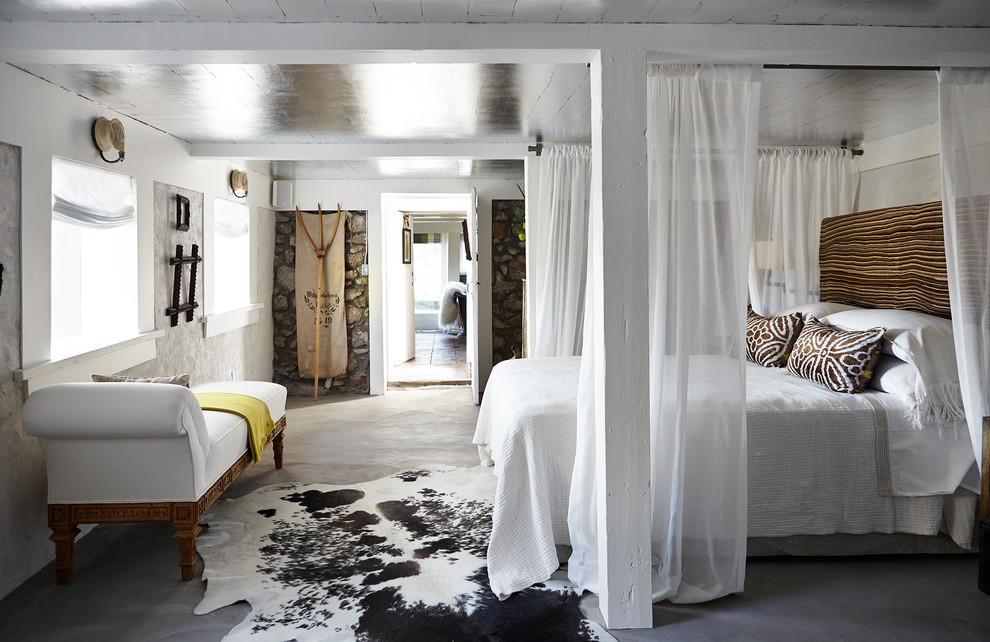Inspiration for a country master bedroom in New York with white walls and concrete floors.