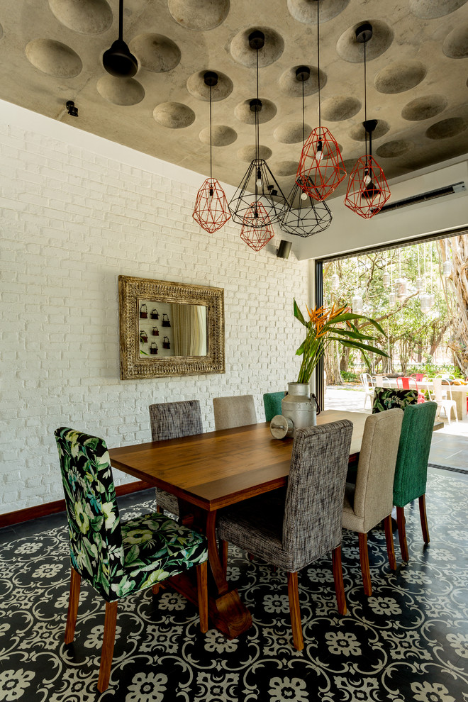 Inspiration for an eclectic dining room in Mumbai with white walls and no fireplace.