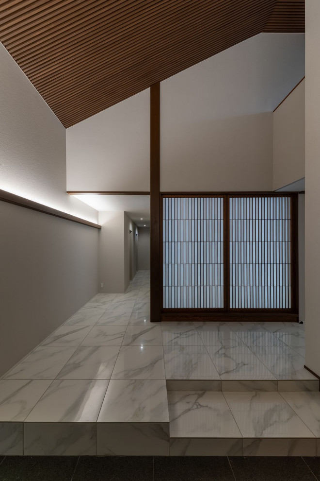 Idee per un grande ingresso etnico con pareti grigie, pavimento con piastrelle in ceramica, una porta scorrevole, una porta marrone, pavimento bianco, soffitto in legno e carta da parati