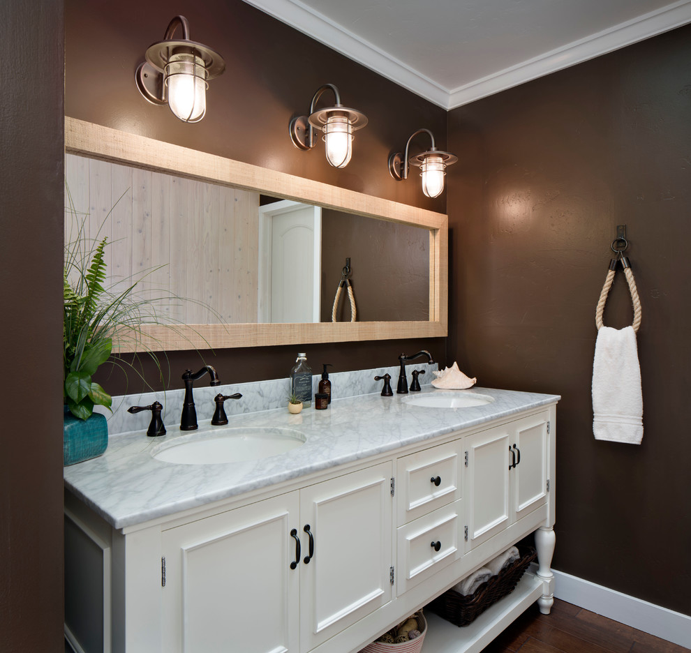Mid-sized beach style master bathroom in San Francisco with an undermount sink, white cabinets, brown walls, a two-piece toilet, medium hardwood floors, marble benchtops and recessed-panel cabinets.