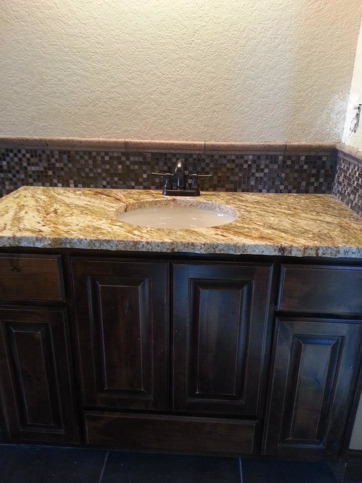 Bathroom - mid-sized multicolored tile and glass tile bathroom idea in Austin with an integrated sink, raised-panel cabinets, dark wood cabinets and white walls