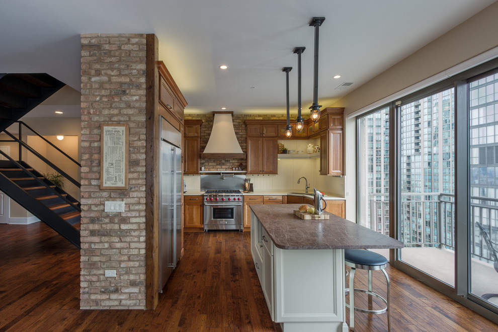 Photo of a mid-sized traditional l-shaped open plan kitchen in Chicago with recessed-panel cabinets, medium wood cabinets, white splashback, with island, a triple-bowl sink, stainless steel appliances and dark hardwood floors.
