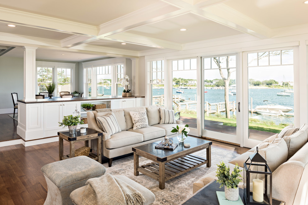 This is an example of a beach style open concept living room in Boston with medium hardwood floors, white walls, no fireplace, no tv and brown floor.
