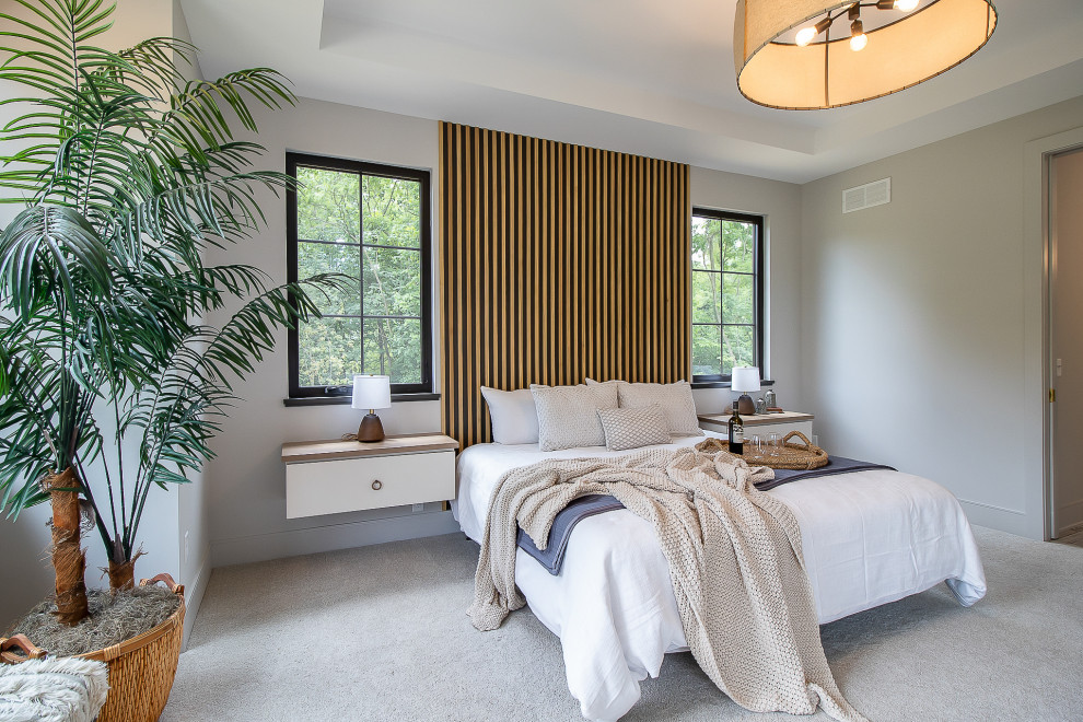 На фото: большая хозяйская спальня в стиле неоклассика (современная классика) с серыми стенами, ковровым покрытием, серым полом, многоуровневым потолком и деревянными стенами