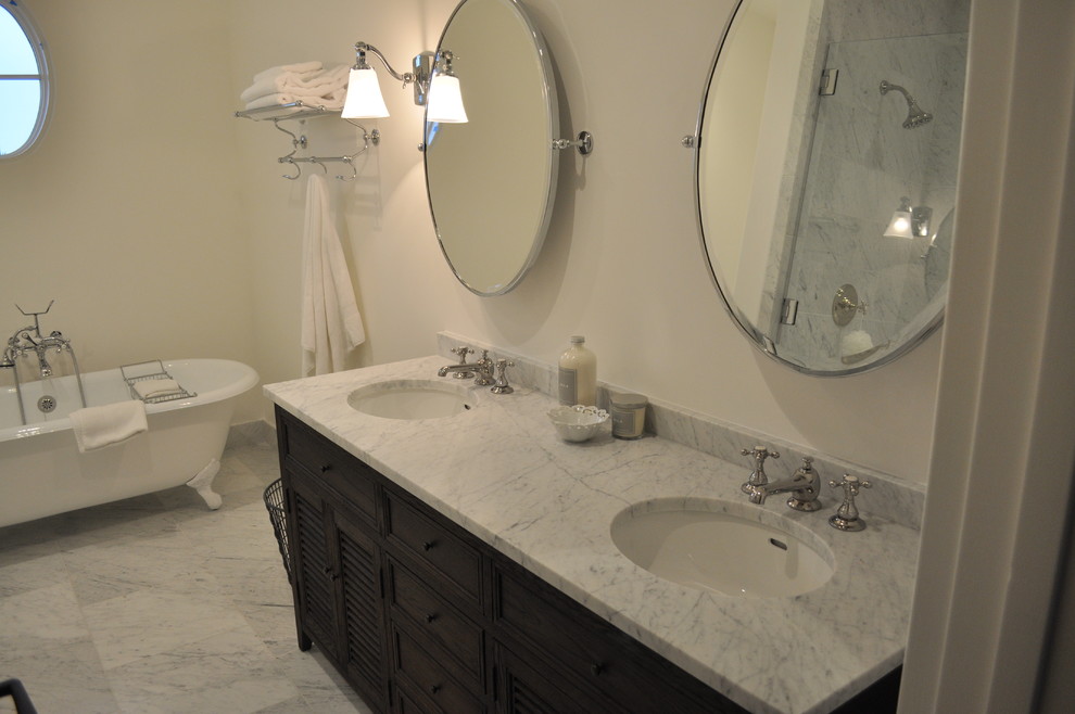 Photo of a contemporary bathroom in Austin with an undermount sink, marble benchtops, a freestanding tub, white walls and marble floors.