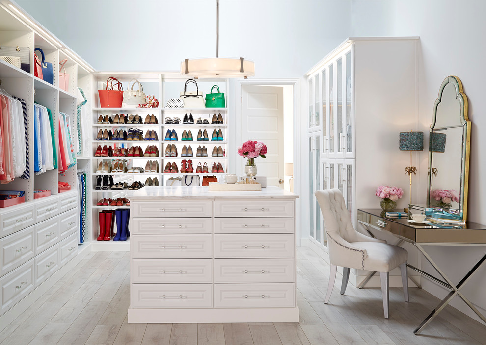 Traditional gender-neutral walk-in wardrobe in Other with white cabinets, light hardwood floors and raised-panel cabinets.