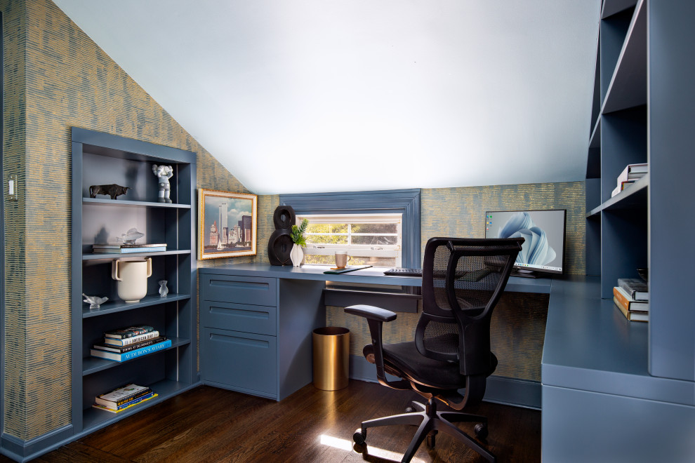 Photo of a medium sized classic study in New York with blue walls, medium hardwood flooring, a built-in desk, brown floors, a vaulted ceiling and wallpapered walls.