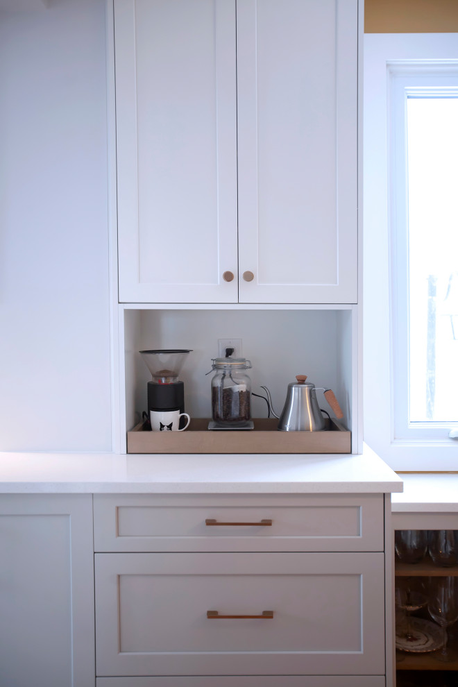 Mid-sized transitional single-wall eat-in kitchen photo with an undermount sink, shaker cabinets, white cabinets, quartz countertops, porcelain backsplash, stainless steel appliances, no island and white countertops