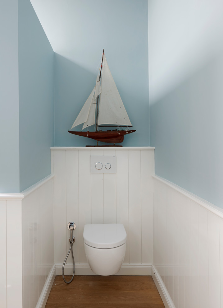 Badezimmer En Suite mit Schrankfronten im Shaker-Stil, weißen Schränken, Wandtoilette mit Spülkasten, blauer Wandfarbe, gebeiztem Holzboden, Waschtisch aus Holz und beigem Boden in Hamburg
