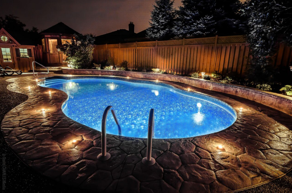 Inspiration for a mid-sized contemporary backyard custom-shaped pool in Toronto with stamped concrete.