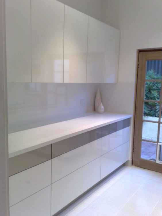 This is an example of a mid-sized traditional galley dedicated laundry room in Perth with flat-panel cabinets, white cabinets, laminate benchtops, white walls and ceramic floors.