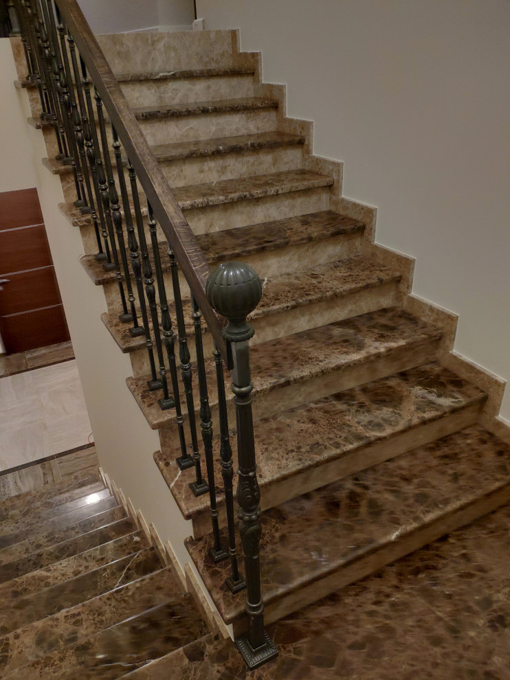 Elegant marble u-shaped metal railing staircase photo in Saint Petersburg with marble risers
