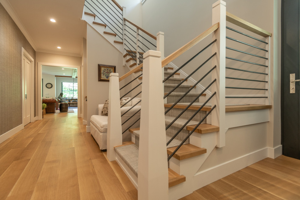 Country wood l-shaped staircase in New York with painted wood risers and cable railing.