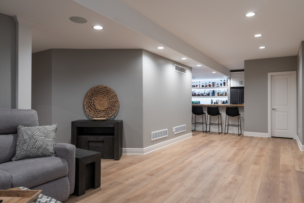 Ejemplo de sótano en el subsuelo minimalista de tamaño medio con bar en casa, paredes grises, suelo vinílico, suelo beige y todos los diseños de techos