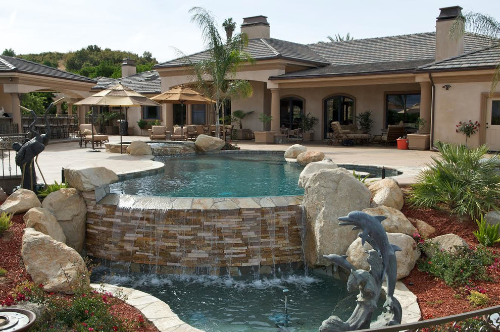 Mid-sized transitional backyard concrete paver and custom-shaped lap hot tub photo in Los Angeles
