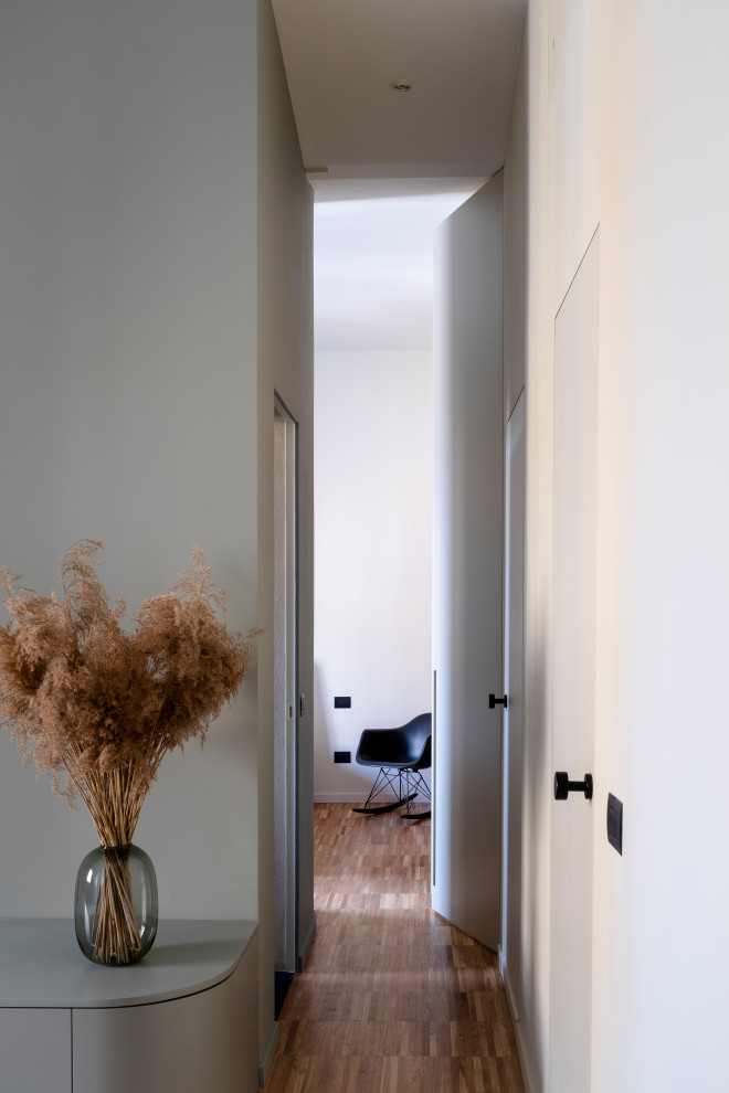 Design ideas for a mid-sized contemporary hallway in Milan with green walls and medium hardwood floors.
