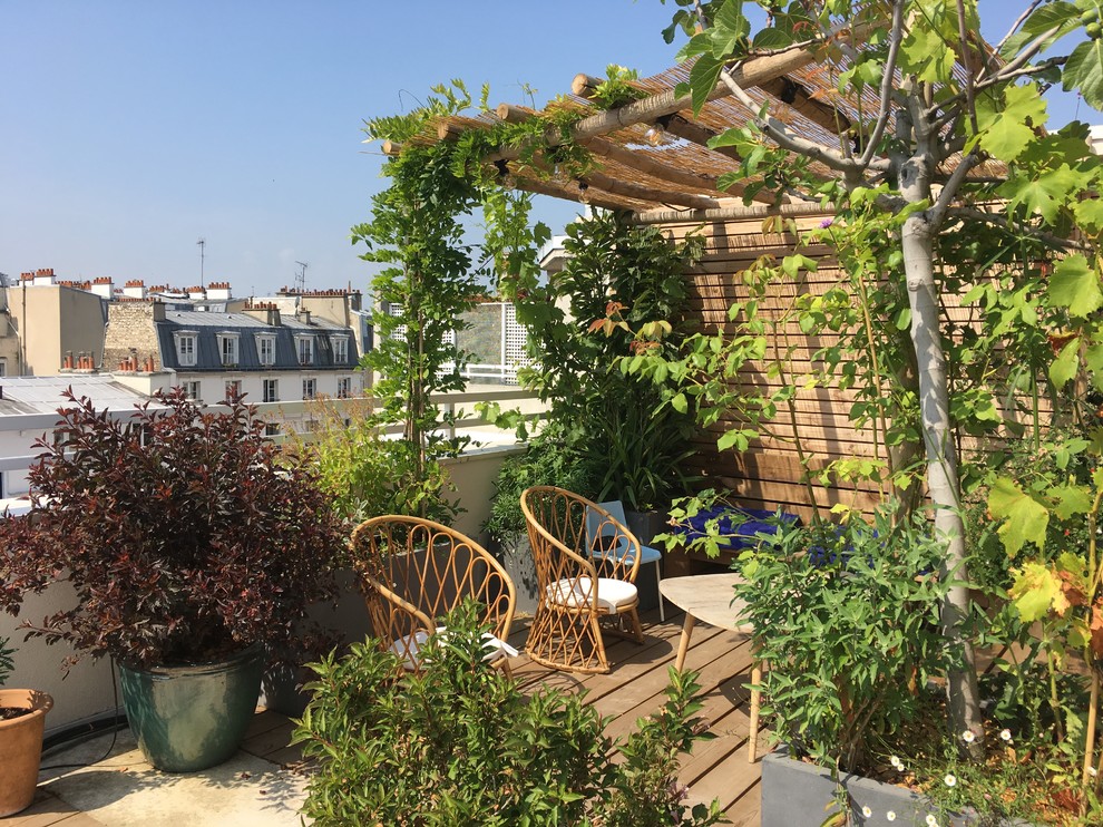 Photo of a large modern rooftop deck in Paris with a container garden and a pergola.