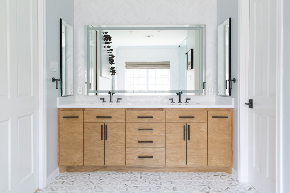 This is an example of a mid-sized transitional master wet room bathroom in San Francisco with a freestanding tub, a one-piece toilet, mosaic tile floors, an undermount sink, a hinged shower door, flat-panel cabinets, light wood cabinets, grey walls, grey floor, white benchtops, a double vanity and a built-in vanity.