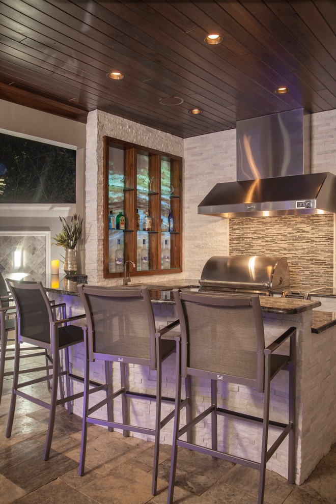 Design ideas for a modern kitchen in Tampa with granite benchtops, multi-coloured splashback, glass tile splashback, stainless steel appliances and travertine floors.
