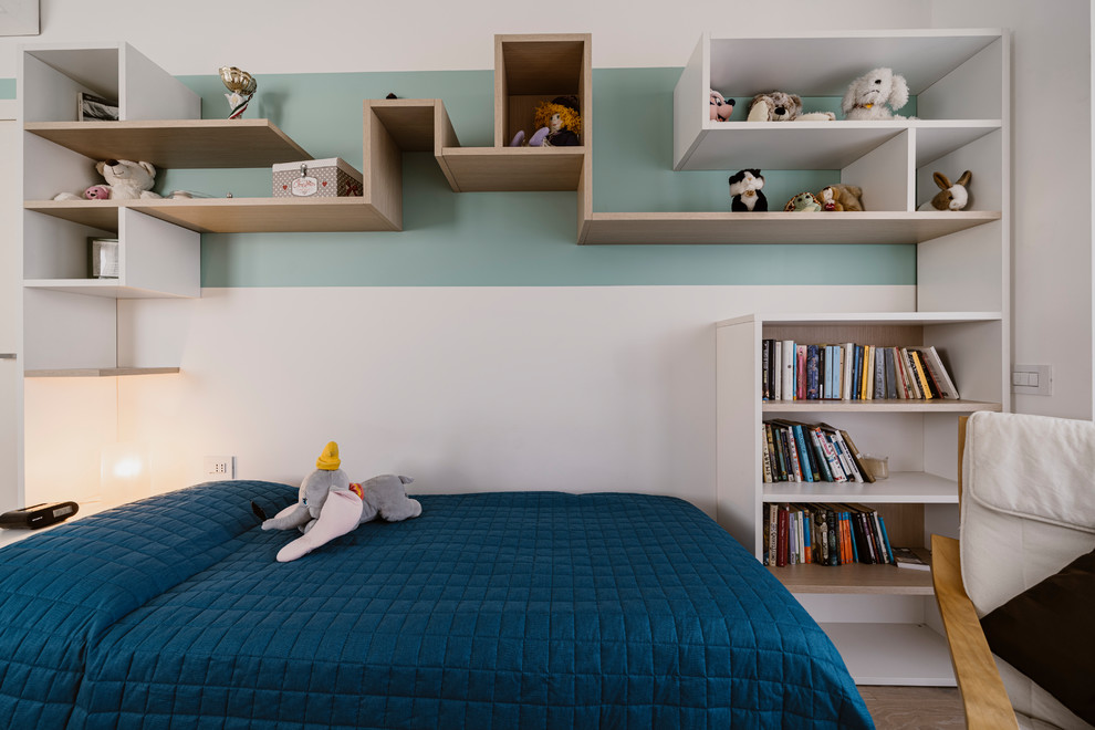 This is an example of a small modern kids' room for girls in Milan with multi-coloured walls, light hardwood floors and beige floor.