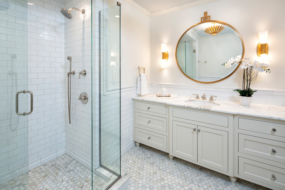 Photo of a mediterranean master bathroom in Minneapolis with white cabinets, a corner shower, a one-piece toilet, white tile, cement tile, white walls, marble floors, an undermount sink, marble benchtops, white floor, a hinged shower door, yellow benchtops, a single vanity, a built-in vanity, decorative wall panelling and recessed-panel cabinets.